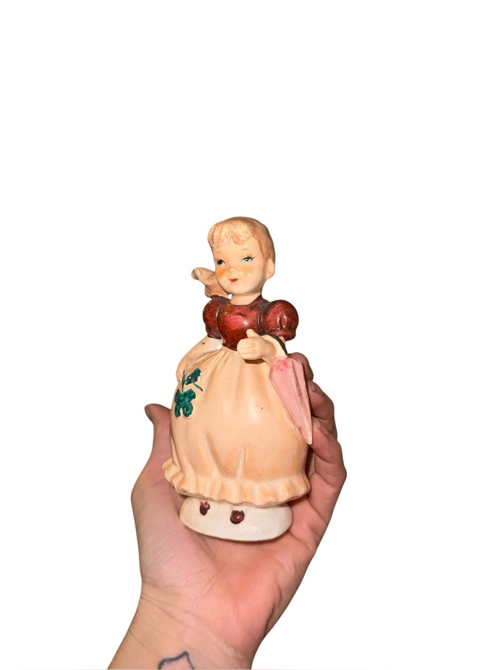 Vintage girl figurine in dress with umbrella and four leaf clover